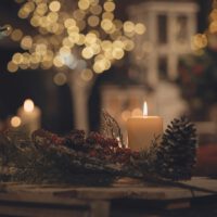 lighted candles on table with pine cones and pine cones