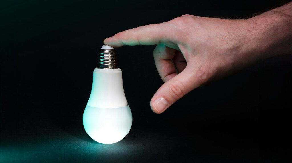 a light bulb being held by a hand